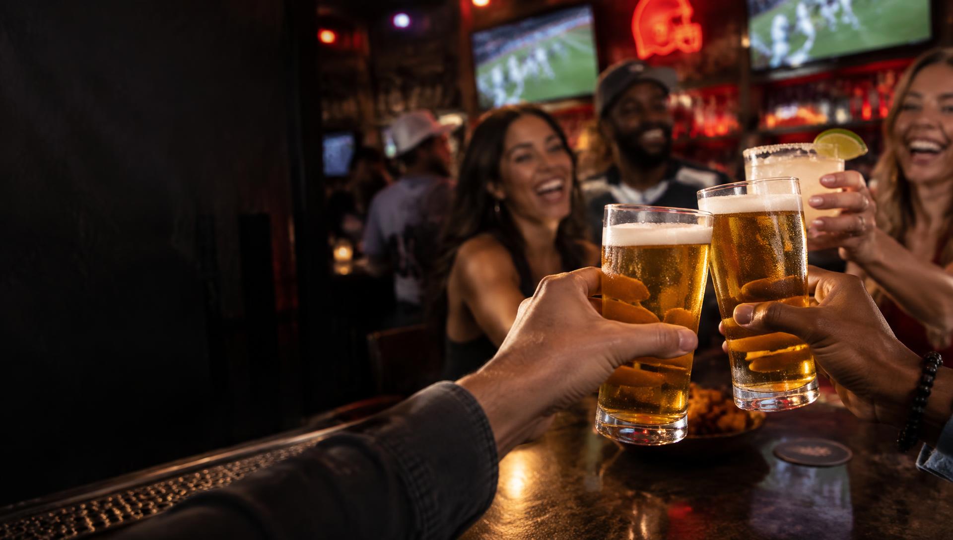 Friends raising a toast on a lively sports bar night